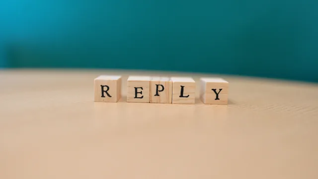 Close-up of wooden blocks spelling 'REPLY' over a wooden surface. Product launch marketing examples with the reasoning laid bare