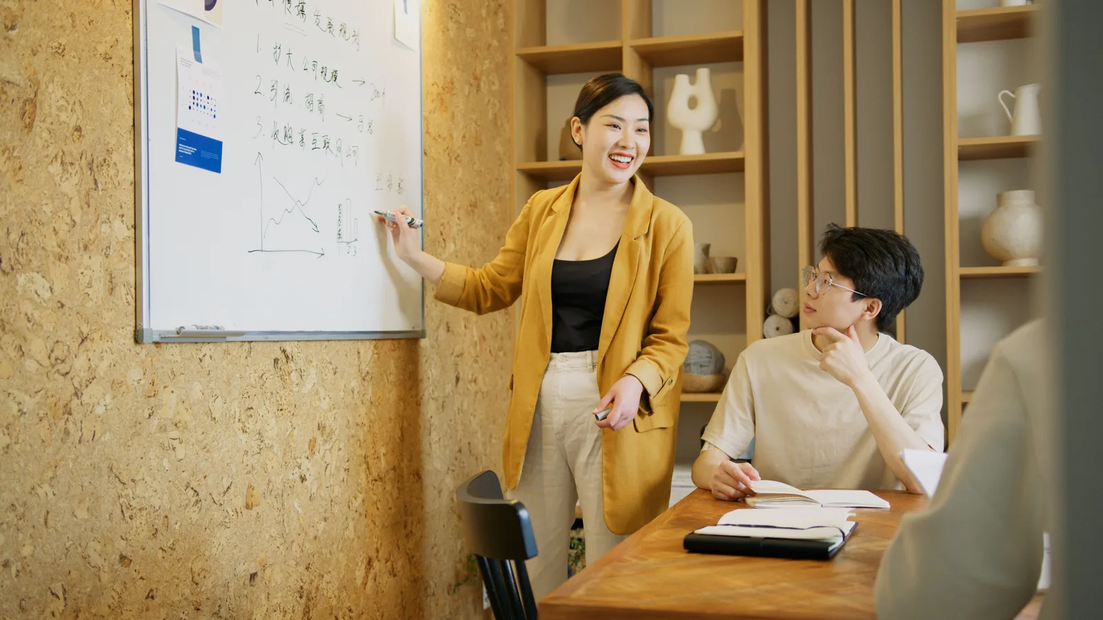 A diverse team discussing strategies in a modern office setting, focusing on whiteboard presentations. Where the product positioning examples agree, and where they do not