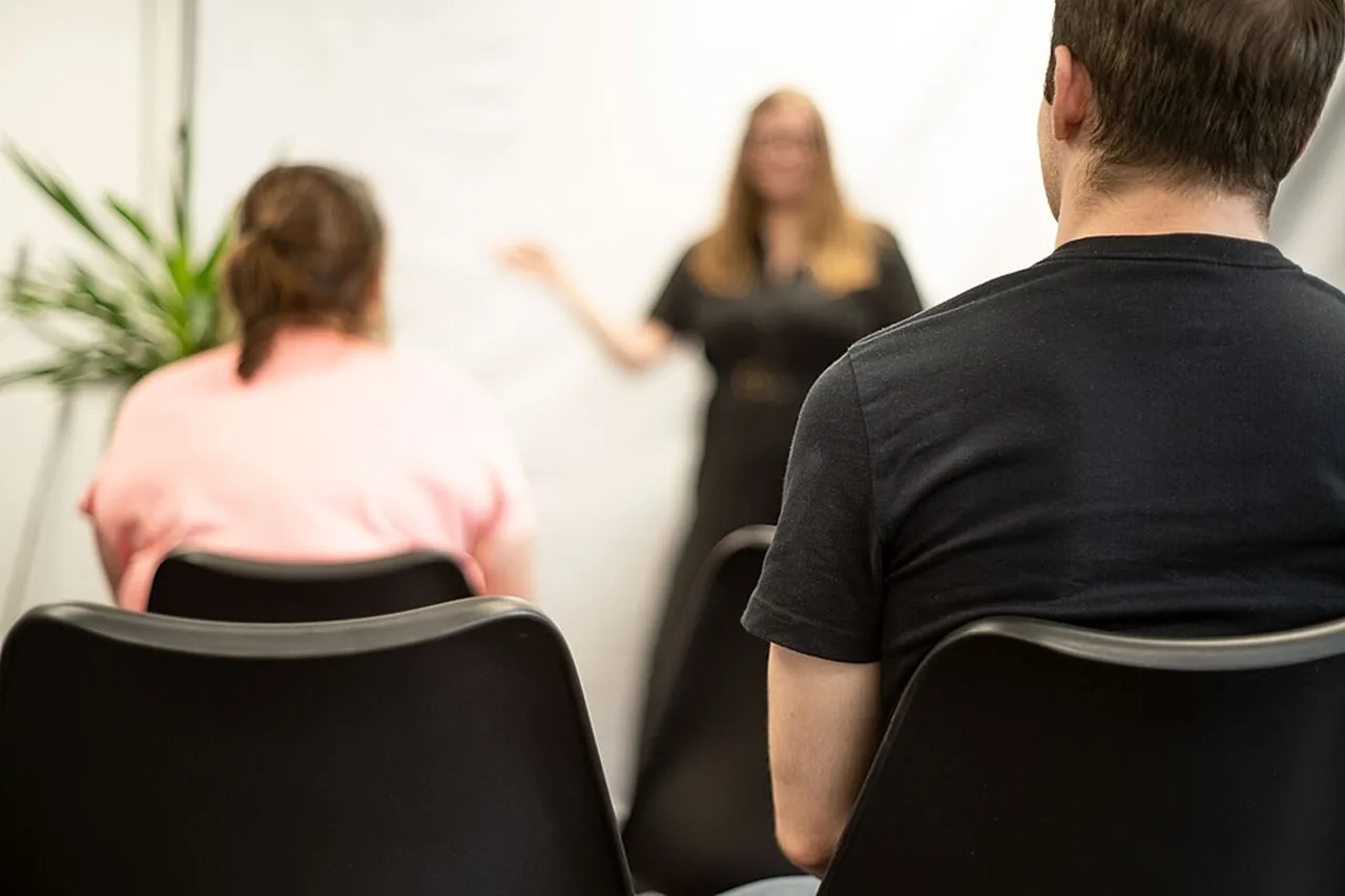 A woman speaks to a small seated audience during a marketing conference.